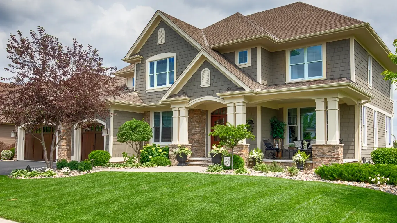 Neatly trimmed shrubs and landscaped beds in front of a two-story home